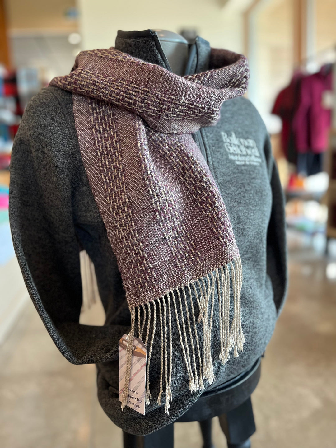 Hand woven scarf displayed on fleece jacket