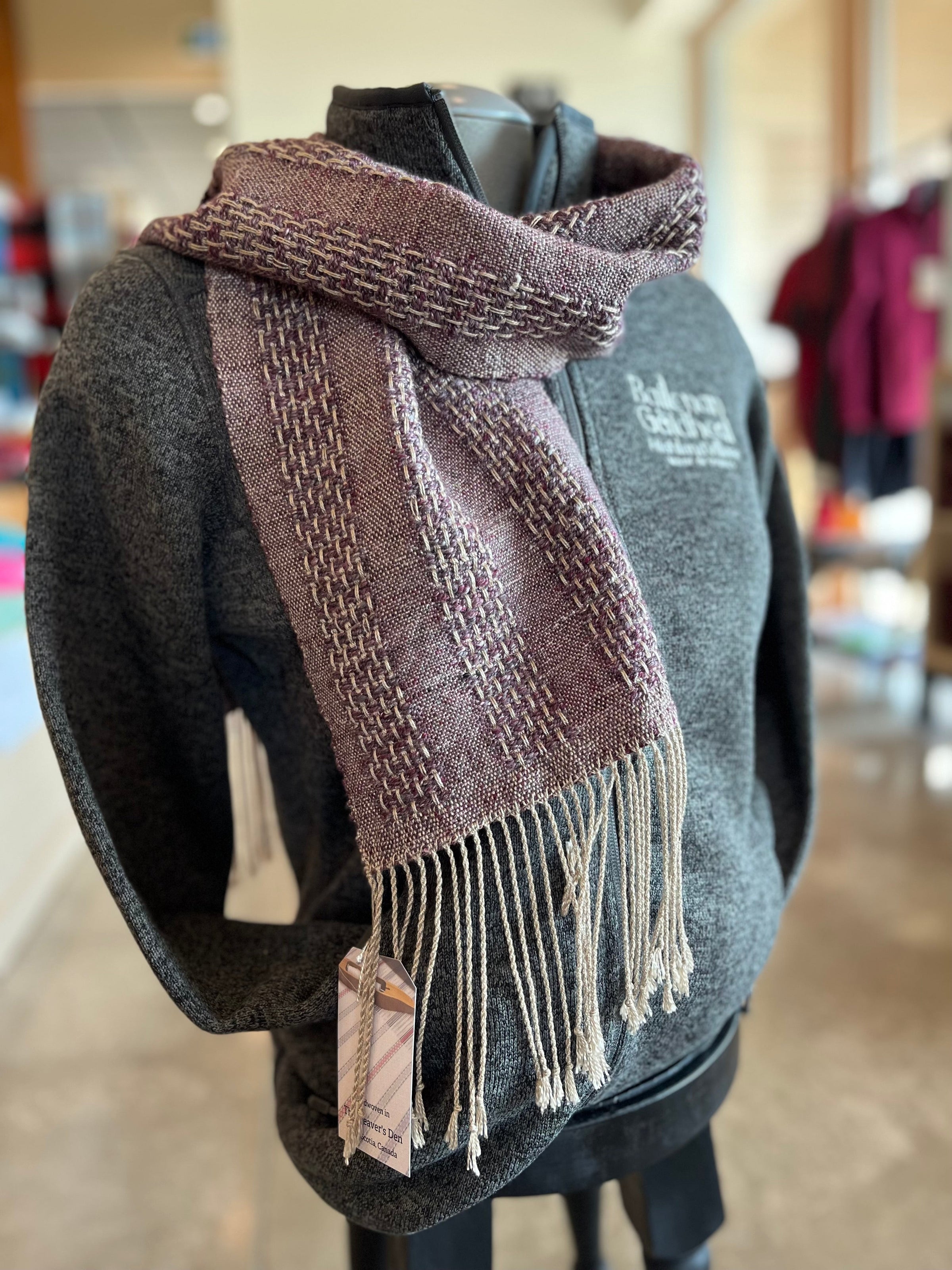 Hand woven scarf displayed on fleece jacket
