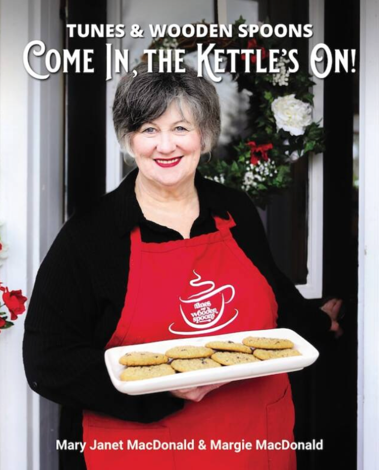 Woman in a red apron holding cookies with text &
