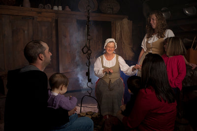 Woman dressed in pioneer clothing with family dressed in modern clothes